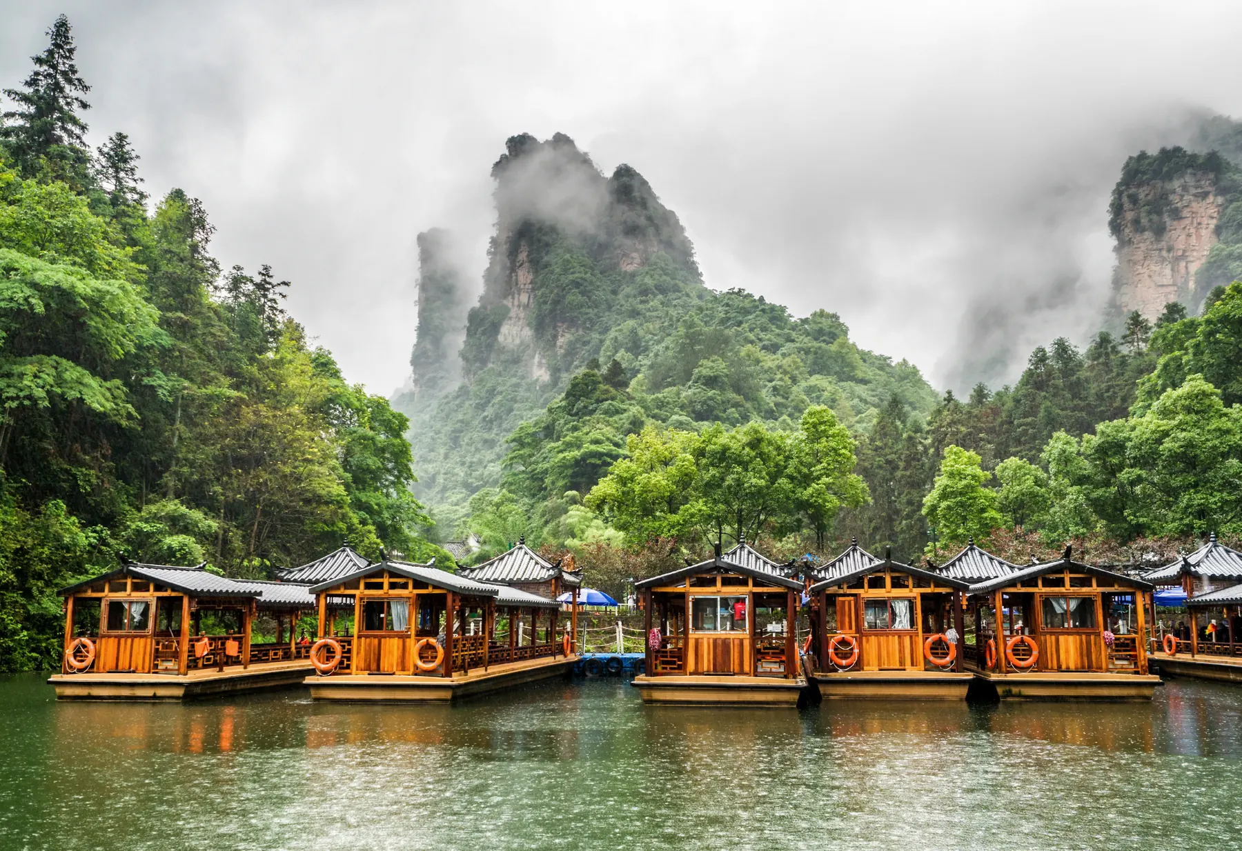 Traditional boats on Baofeng Lake below misty peaks